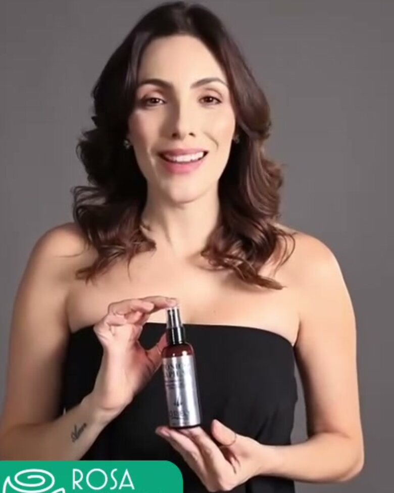 Modelo apresentando um frasco de tônico capilar produzido na fábrica